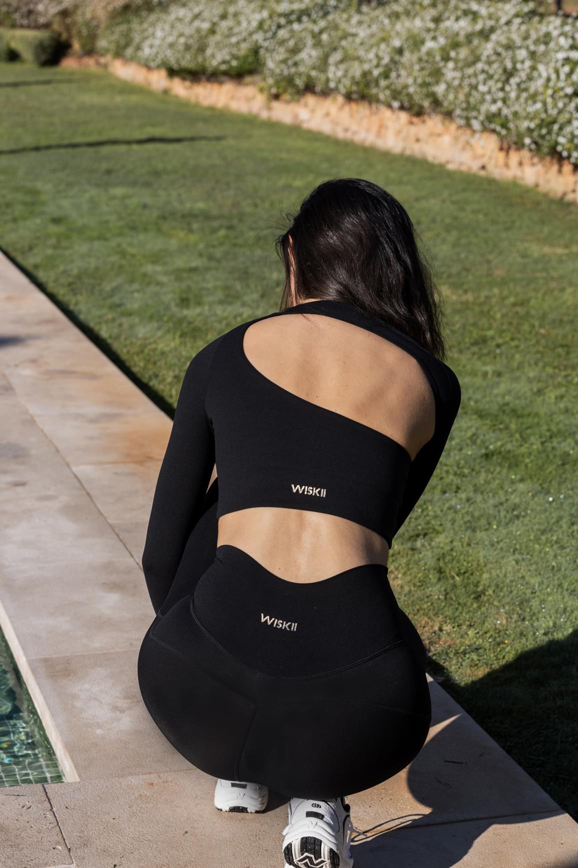Ivory WISKII long sleeve crop top with unique cut design, made from soft fabric, styled with a fitted silhouette.