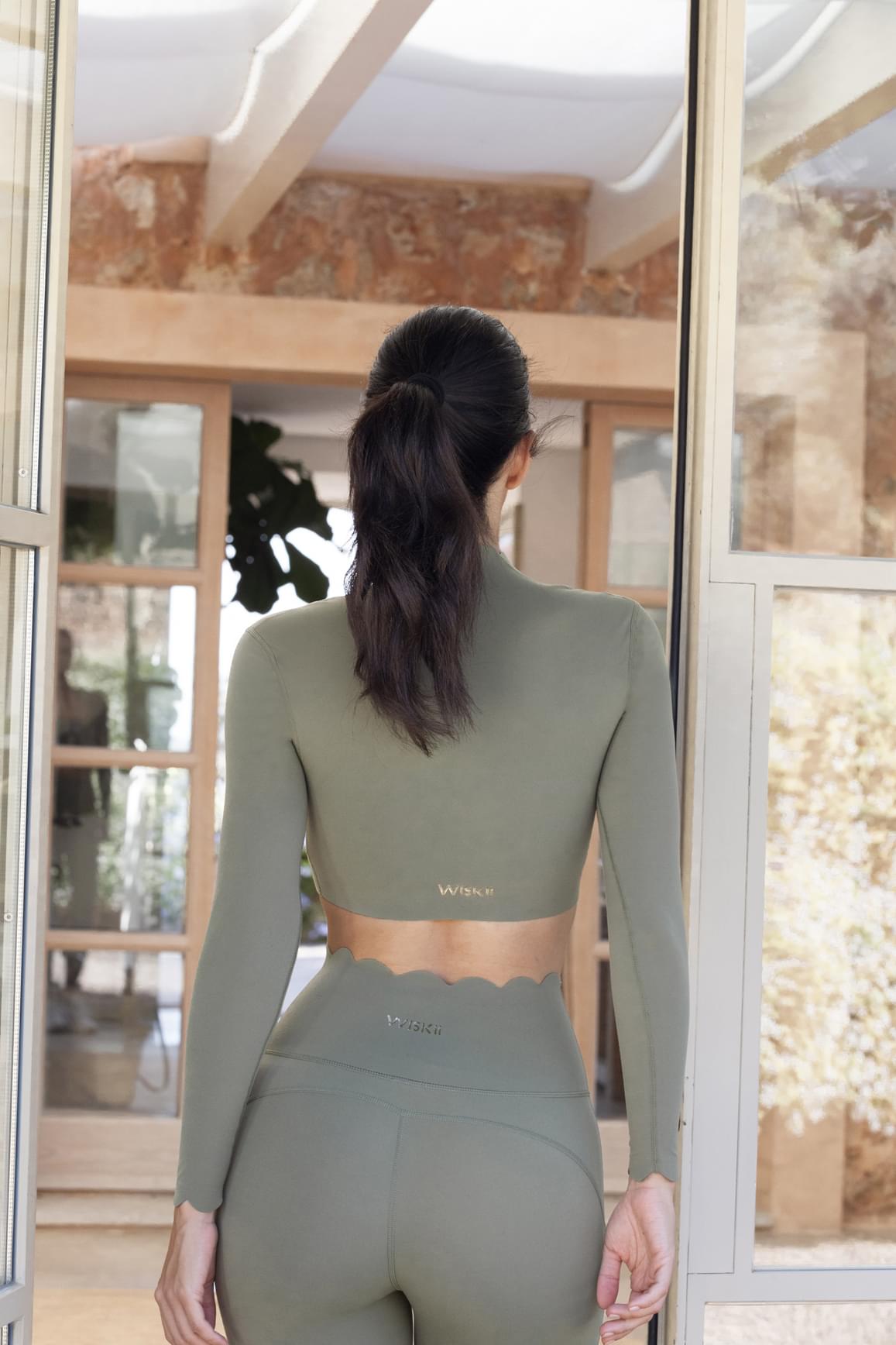 Ivory 7/8 high-waist energy leggings by WISKII, shown on a model, highlighting the stretchy, fitted design for active wear.
