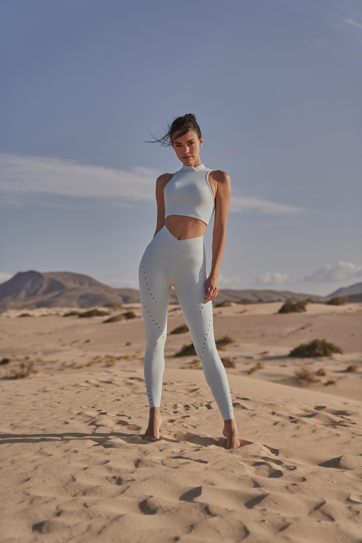 Ivory V-waist laser cut sports leggings by WISKII, close-up of the stylish cut-out design and stretchy fabric for active wear.