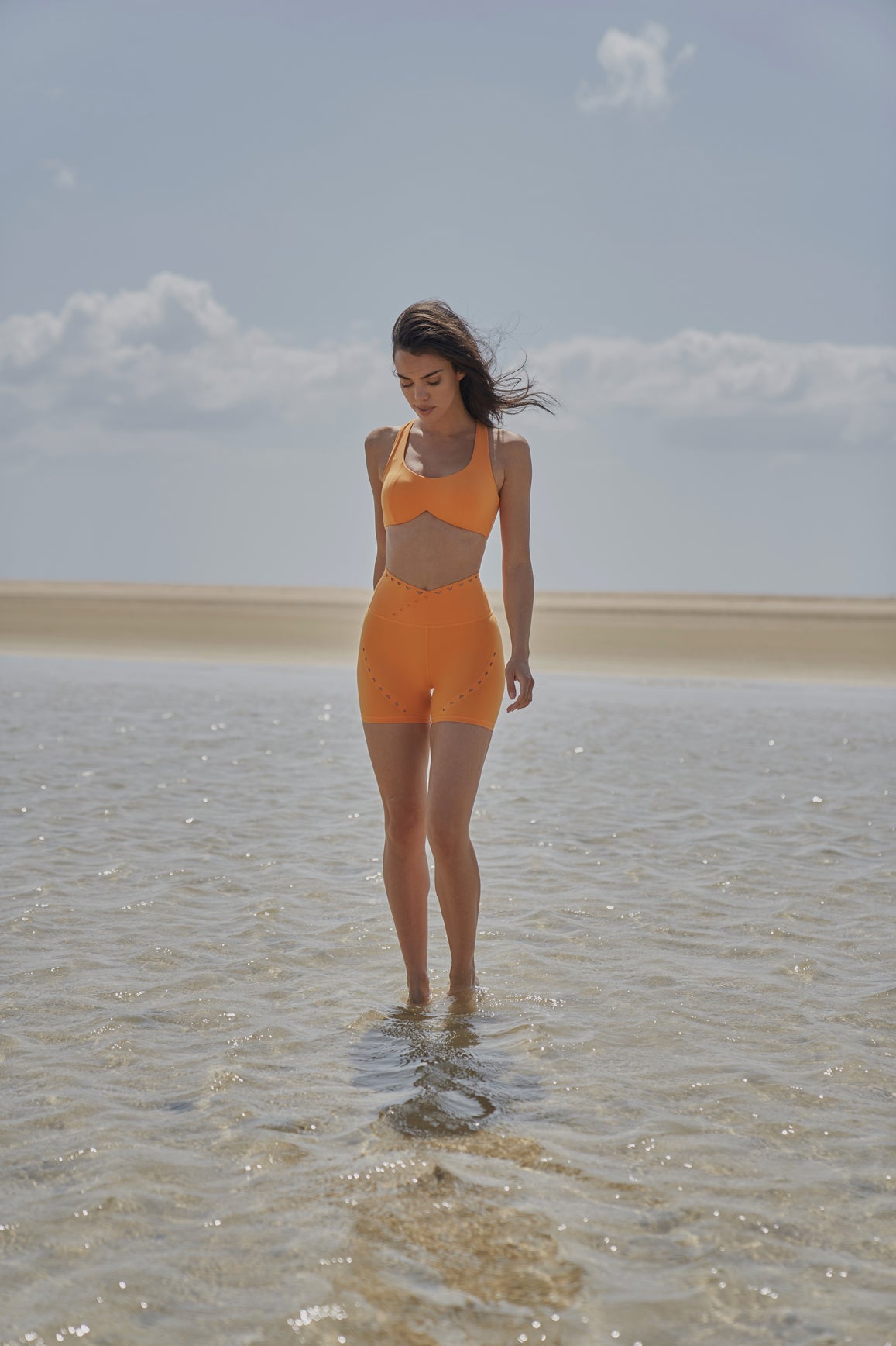 WISKII V-waist laser cut orange sports shorts with flame design, lightweight activewear for running or gym workouts.