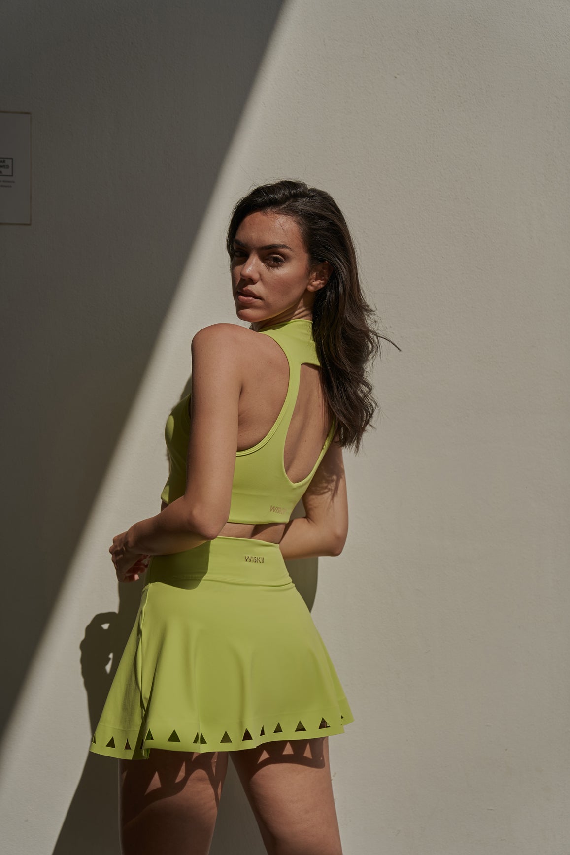 WISKII V-waist laser cut tennis skirt in vibrant lime green, designed for sporty style and comfort.