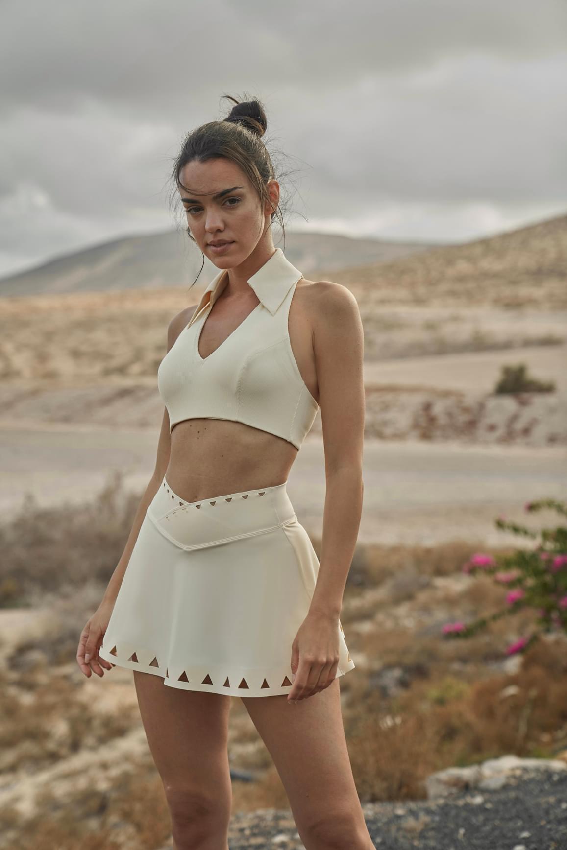 Ivory V-waist laser cut tennis skirt by WISKII with stylish cut-out details and a fitted silhouette for active wear.