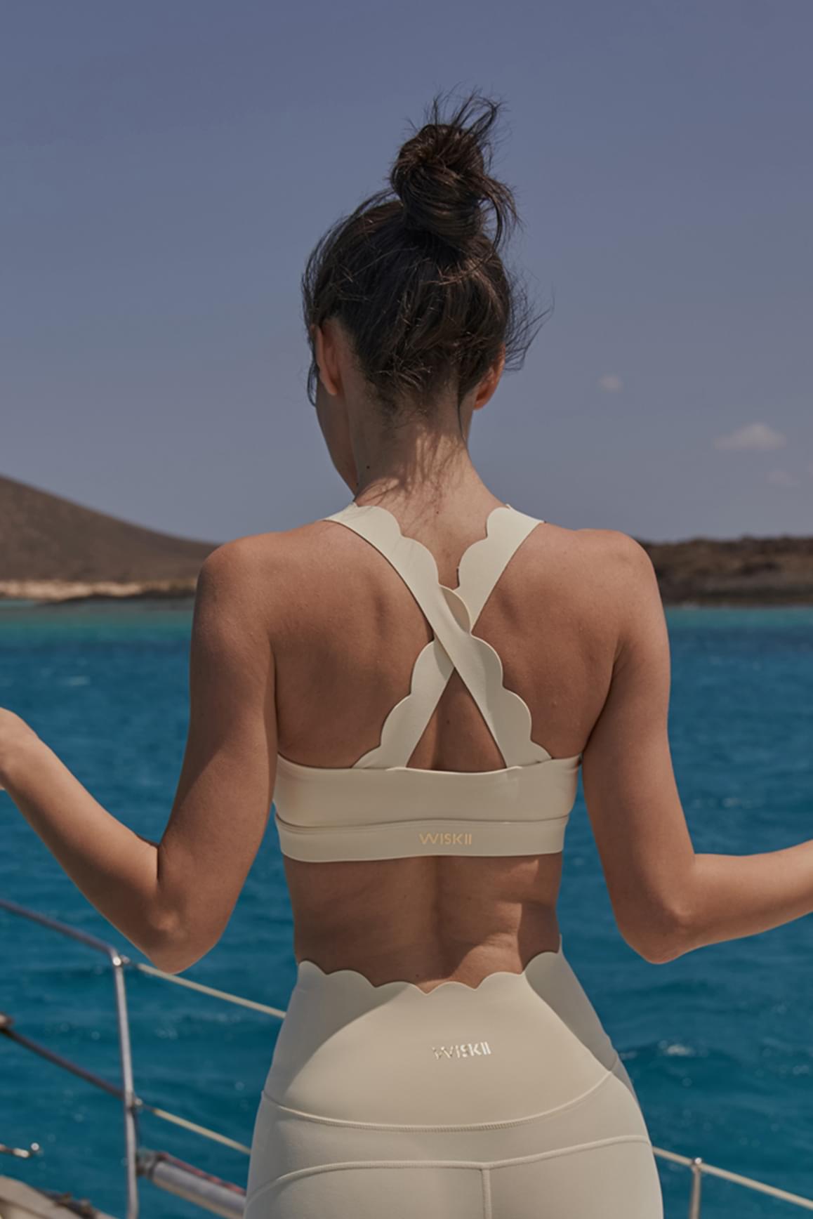 WISKII ivory cross back sports bra with supportive design and adjustable straps, ideal for activewear and workouts.
