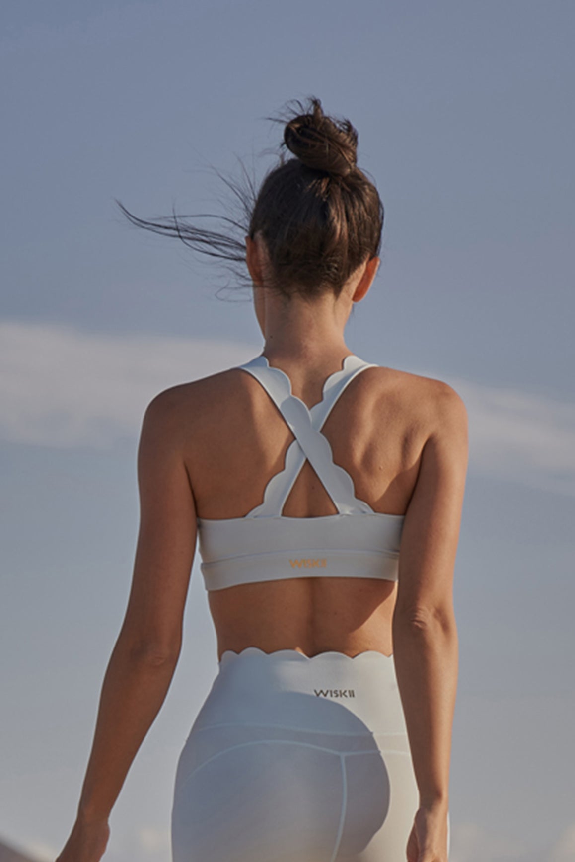 Ivory WISKII Cross Back Sports Bra showing the stylish cross-back design and supportive fit for active wear.