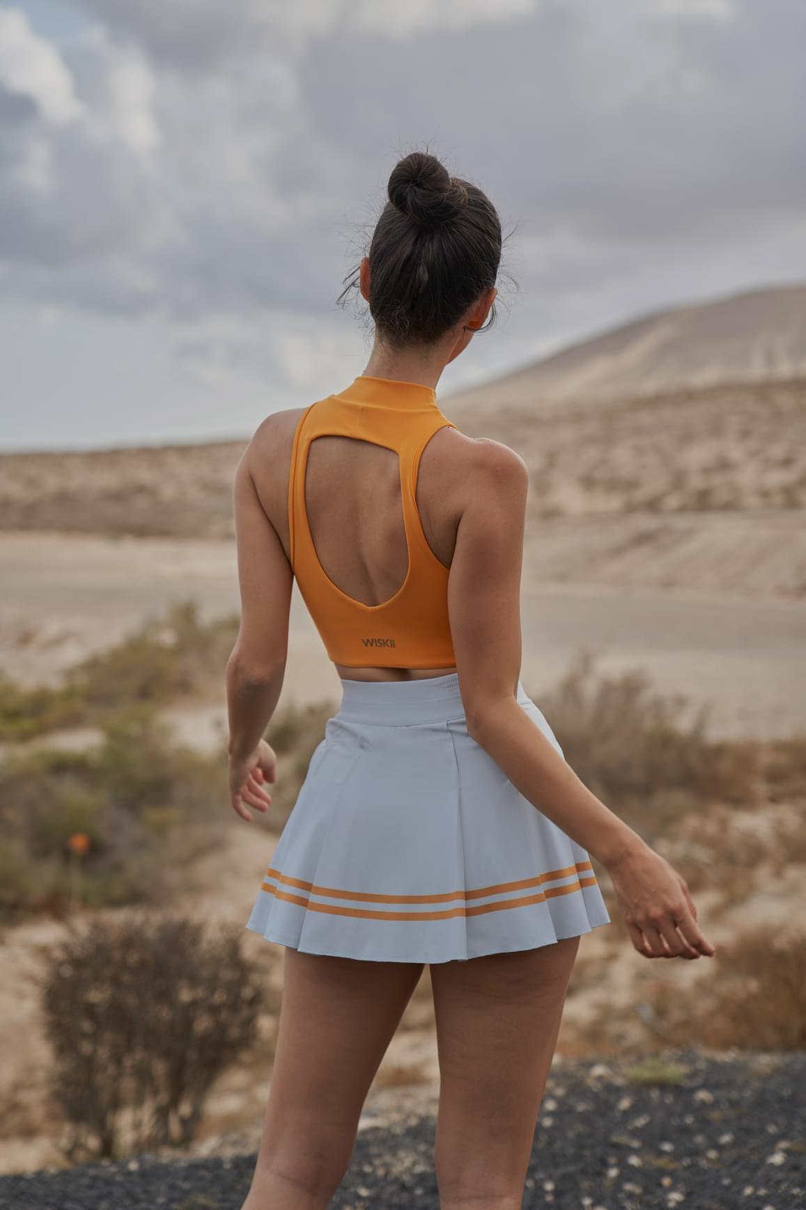 Ivory WISKII sports bra with diamond cutout detail, mock neck design, and supportive fit for active wear.