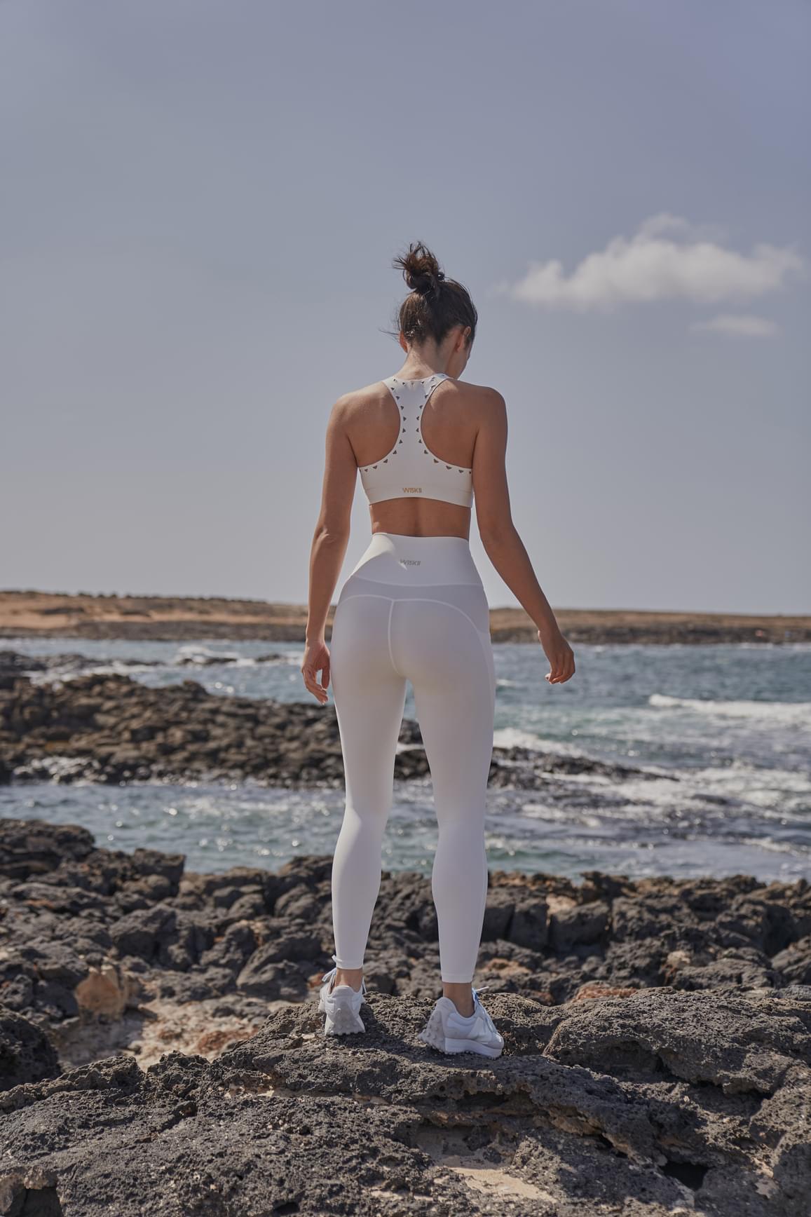 WISKII ivory racerback laser cut sports bra with stylish cutout design and supportive fit for active wear.