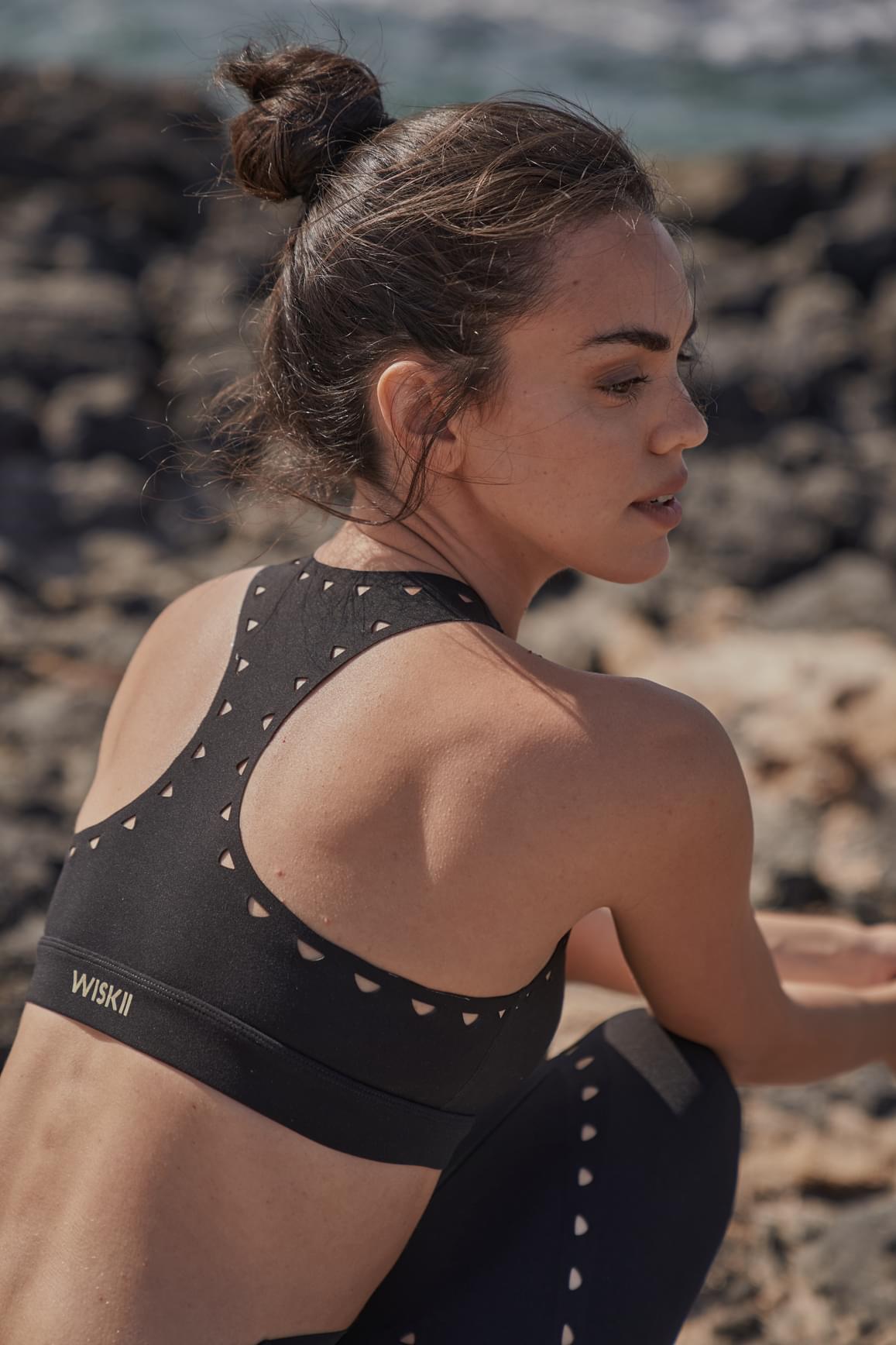 Ivory WISKII Racerback Laser Cut Sports Bra with stylish cut-out details and supportive fit for active wear.
