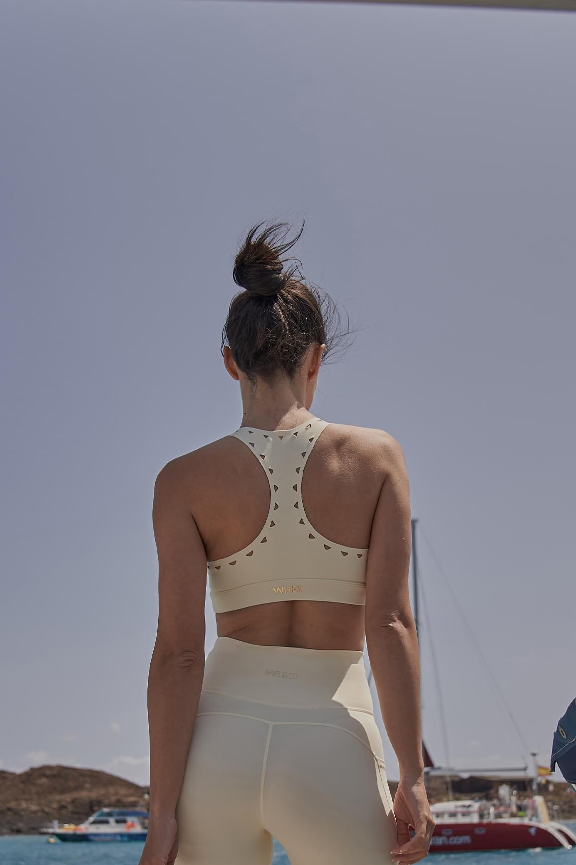 WISKII ivory racerback laser cut sports bra with stylish cutout design and supportive fit, designed for active wear.