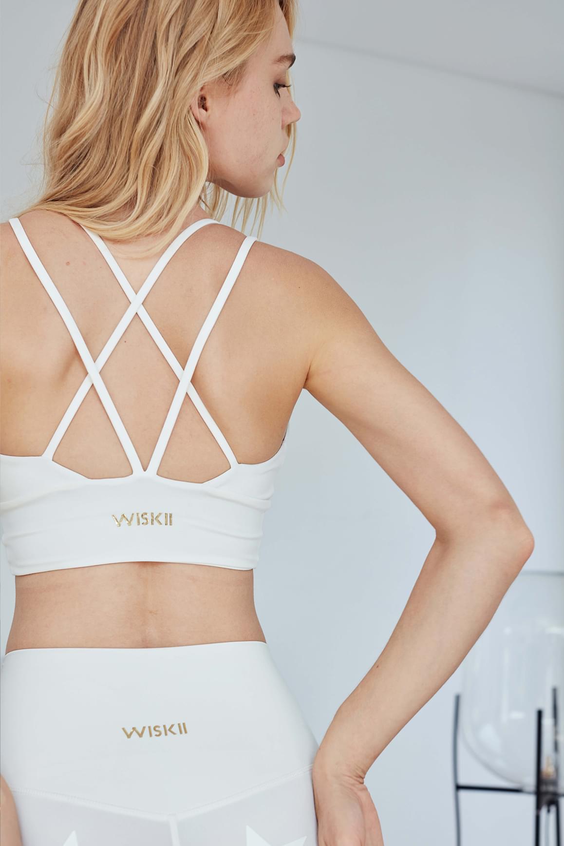 WISKII Suit Yourself Sports Bra in ivory, showing a snug, supportive sports bra with adjustable straps and sleek design.