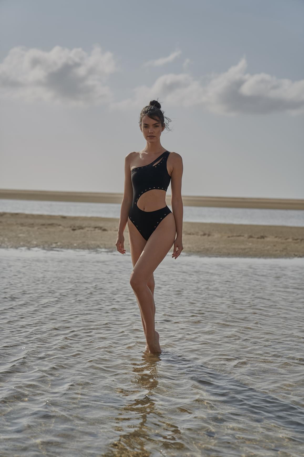 Ivory one-shoulder laser cut swimsuit by WISKII, featuring a stylish cut-out design and sleek fit for beach or poolside wear.