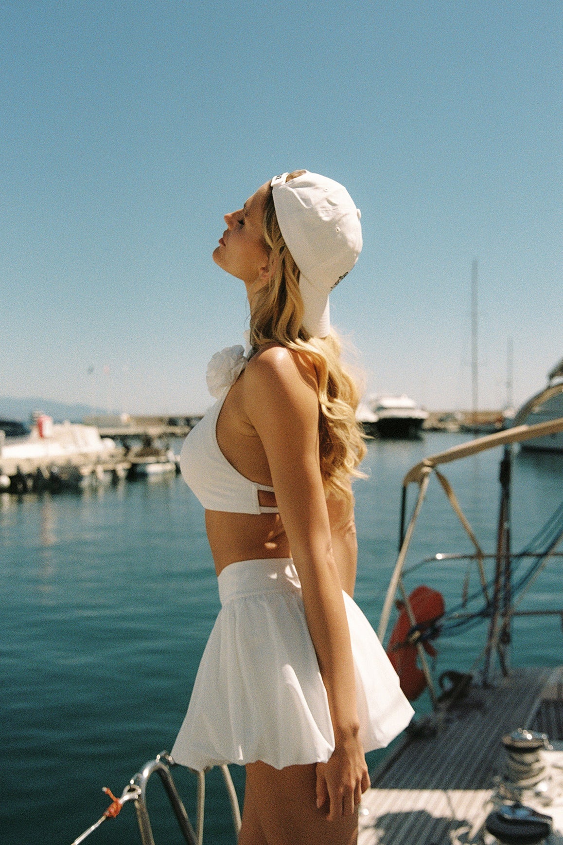 Model wears Riviera Floral Halter Mock Neck Top and Mini Bubble Skirt | Ivory | WISKII Active