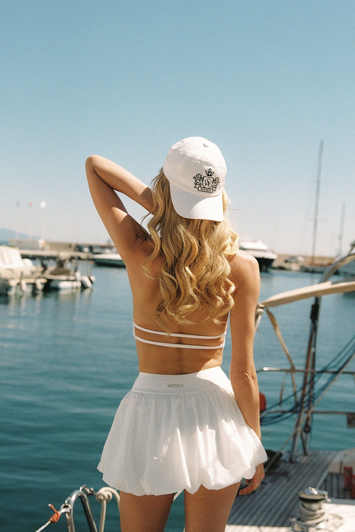 Model wears Riviera Floral Halter Mock Neck Top and Mini Bubble Skirt | Ivory | WISKII Active