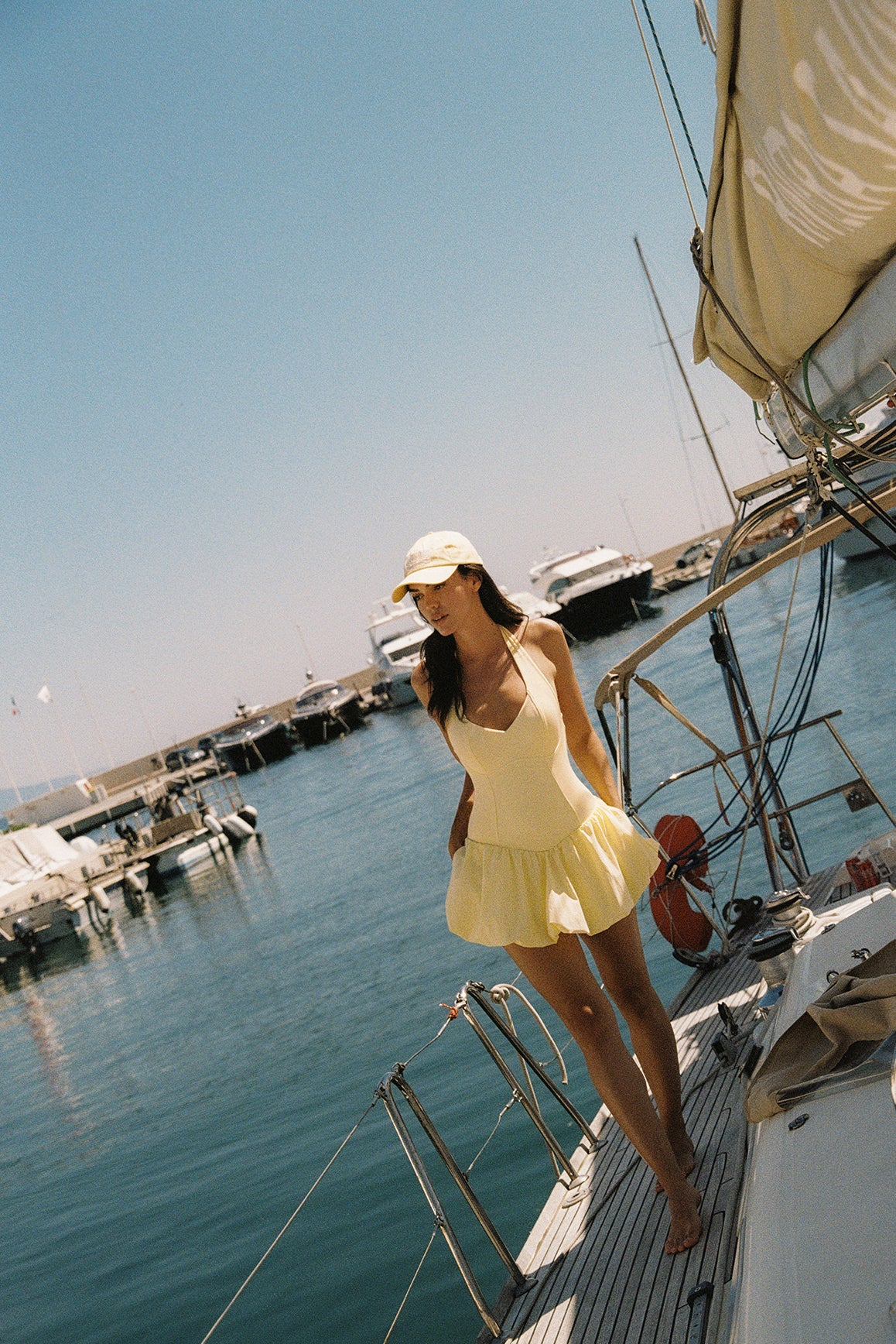 Model wears a Riviera Floral Backless Halter Dress | Lemon Drop | WISKII Active