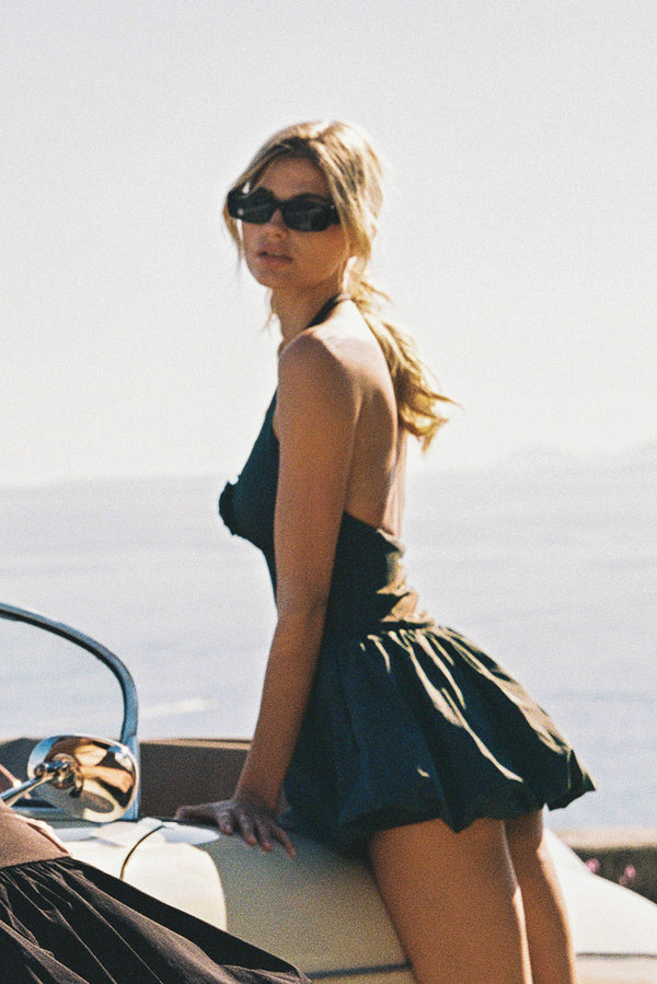 Model wears a Riviera Floral Backless Halter Dress | WISKII Active | Deepsea dress