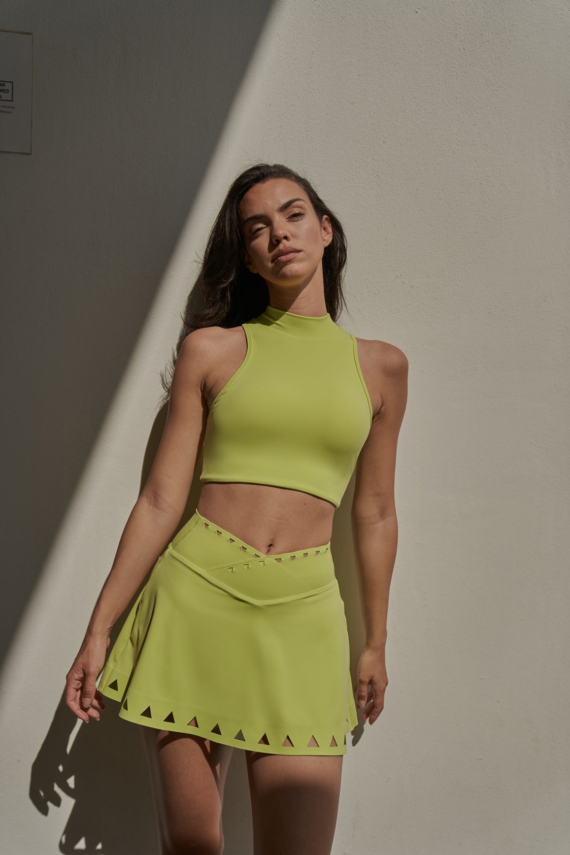 WISKII V-waist laser cut tennis skirt in vibrant lime green, featuring stylish laser cut details and a sleek tennis skirt design.