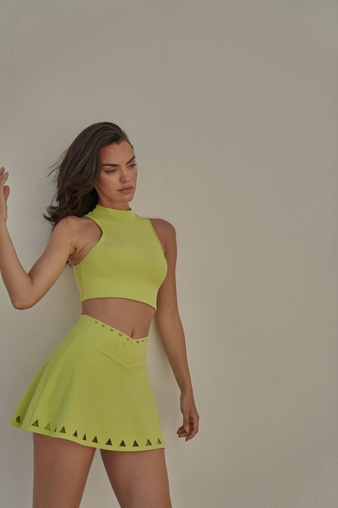 WISKII V-waist laser cut tennis skirt in vibrant bitter lime color, stylish and breathable for active tennis play.