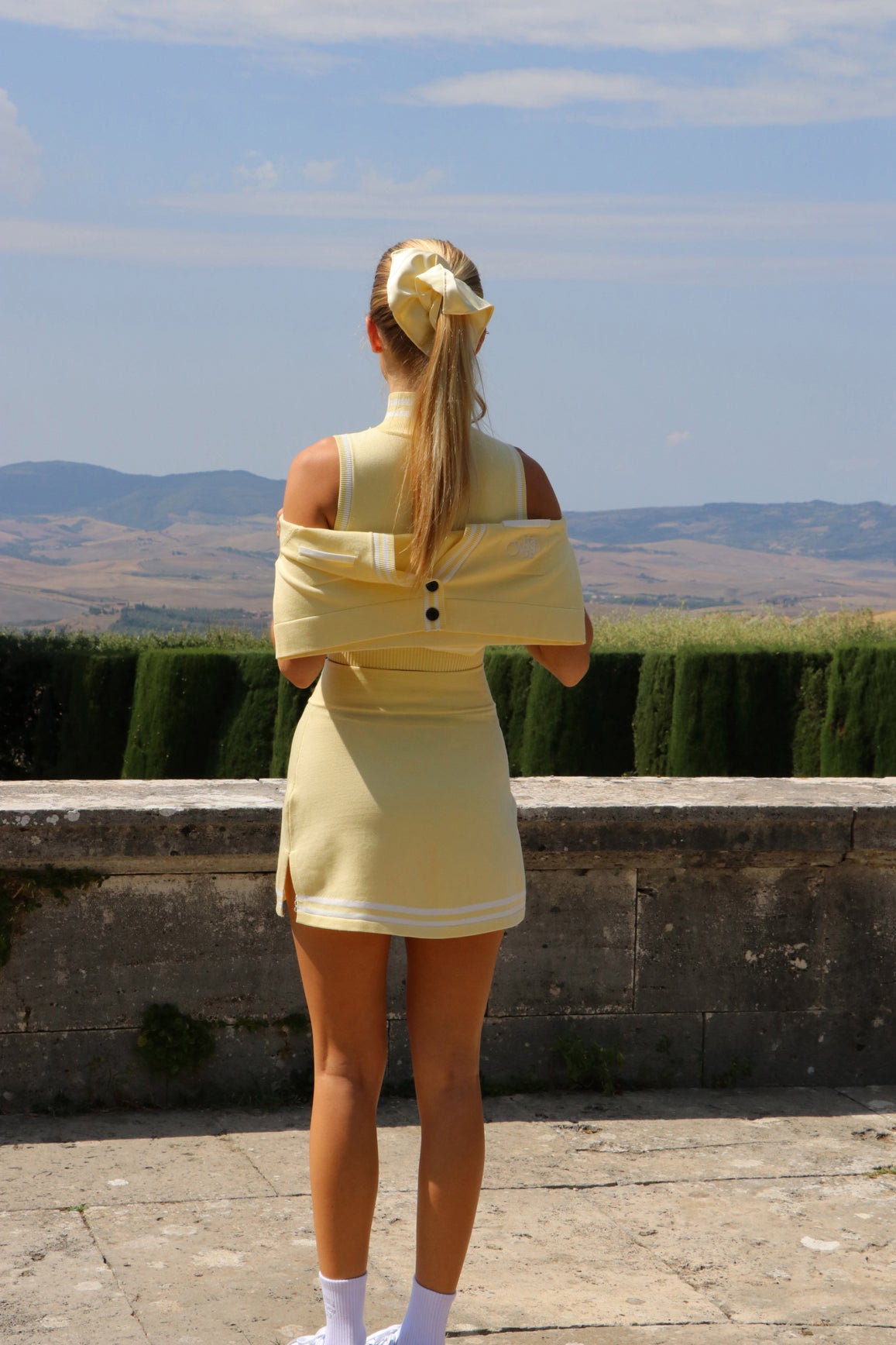 Cream WISKII Mirto Knit Mini Skirt displayed on a model, showcasing its fitted silhouette and soft knit fabric.