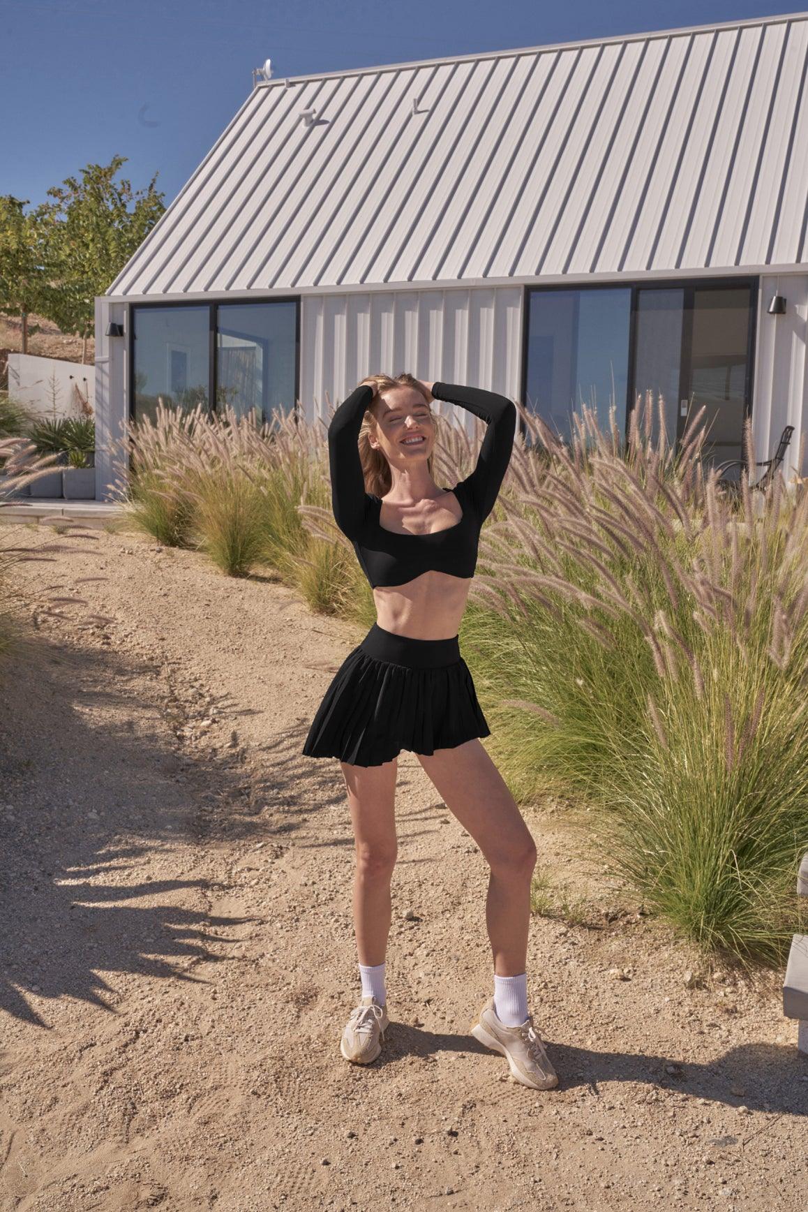 Ivory WISKII Lite Pleated Skirt shown on a model, featuring a flowy, lightweight design with fine pleats for a stylish look.