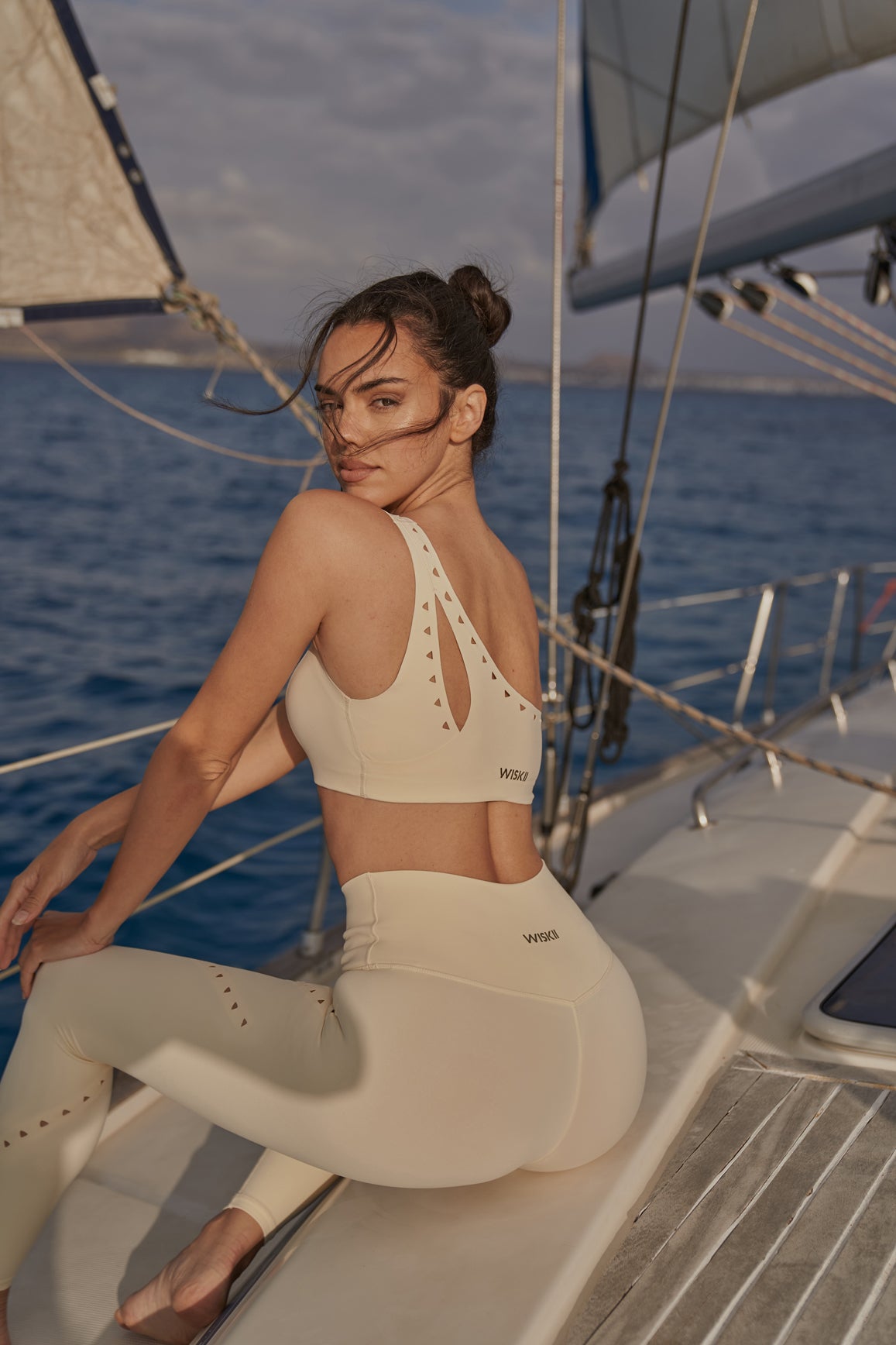 WISKII ivory one-shoulder laser cut sports bra showing sleek design and cut-out details on the front.