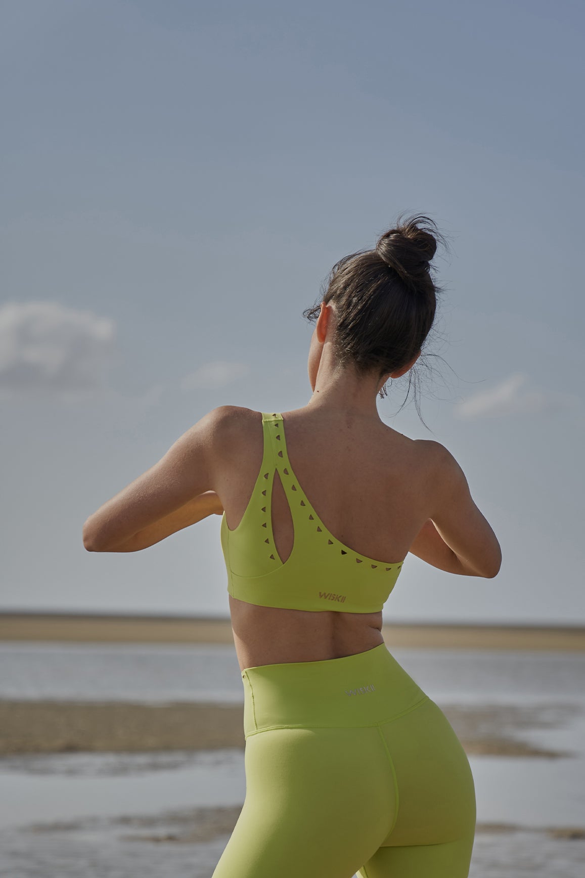 Ivory WISKII one-shoulder laser-cut sports bra with stylish design and supportive fit, ideal for active wear and workouts.